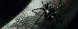 a fierce, black widow spider tattoo crawling menacingly along a forearm.