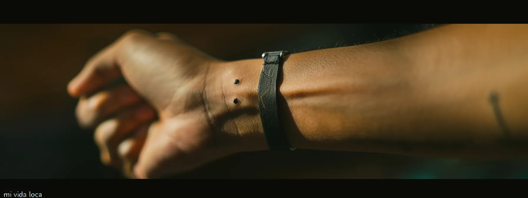 a close-up photo of a person's wrist with a prominent three dots tattoo, symbolizing 